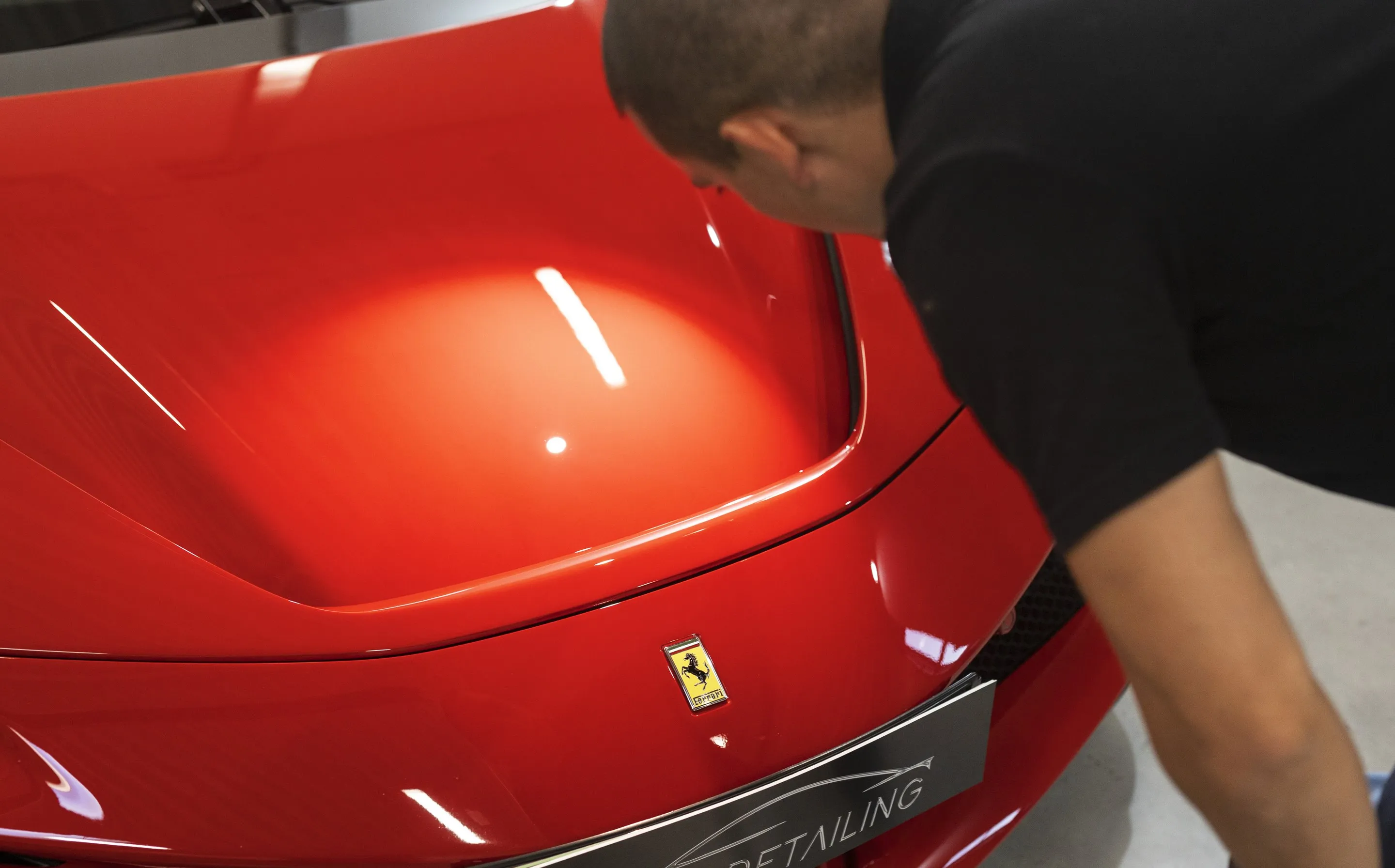 Piros Ferrari fényezésének polírozása gépi polírozóval