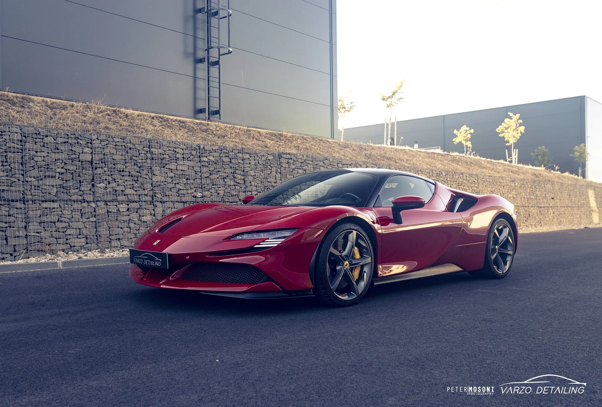 Piros Ferrari SF90 Spider kőfal előtt