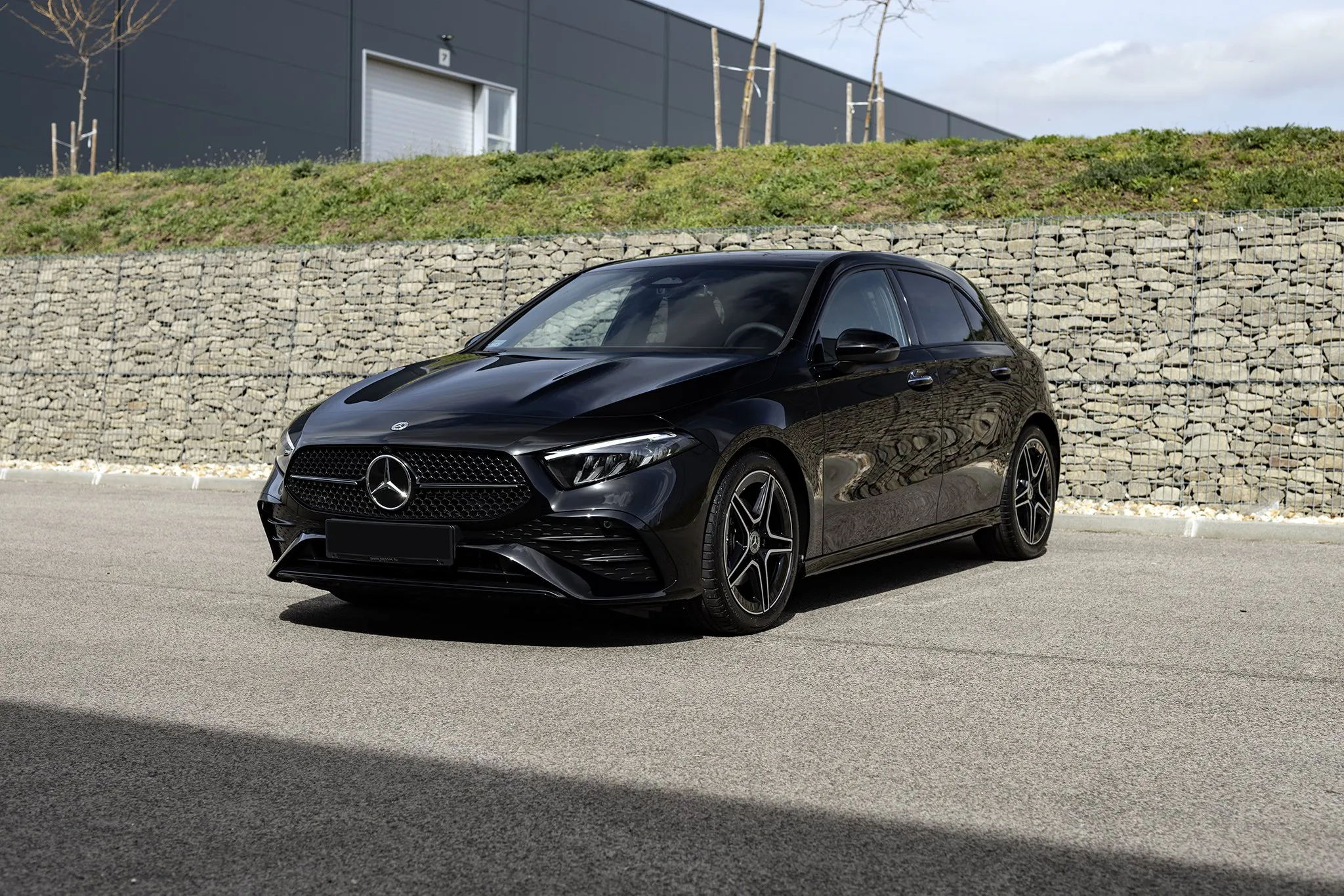 Fekete Mercedes A-osztály kőfal előtt