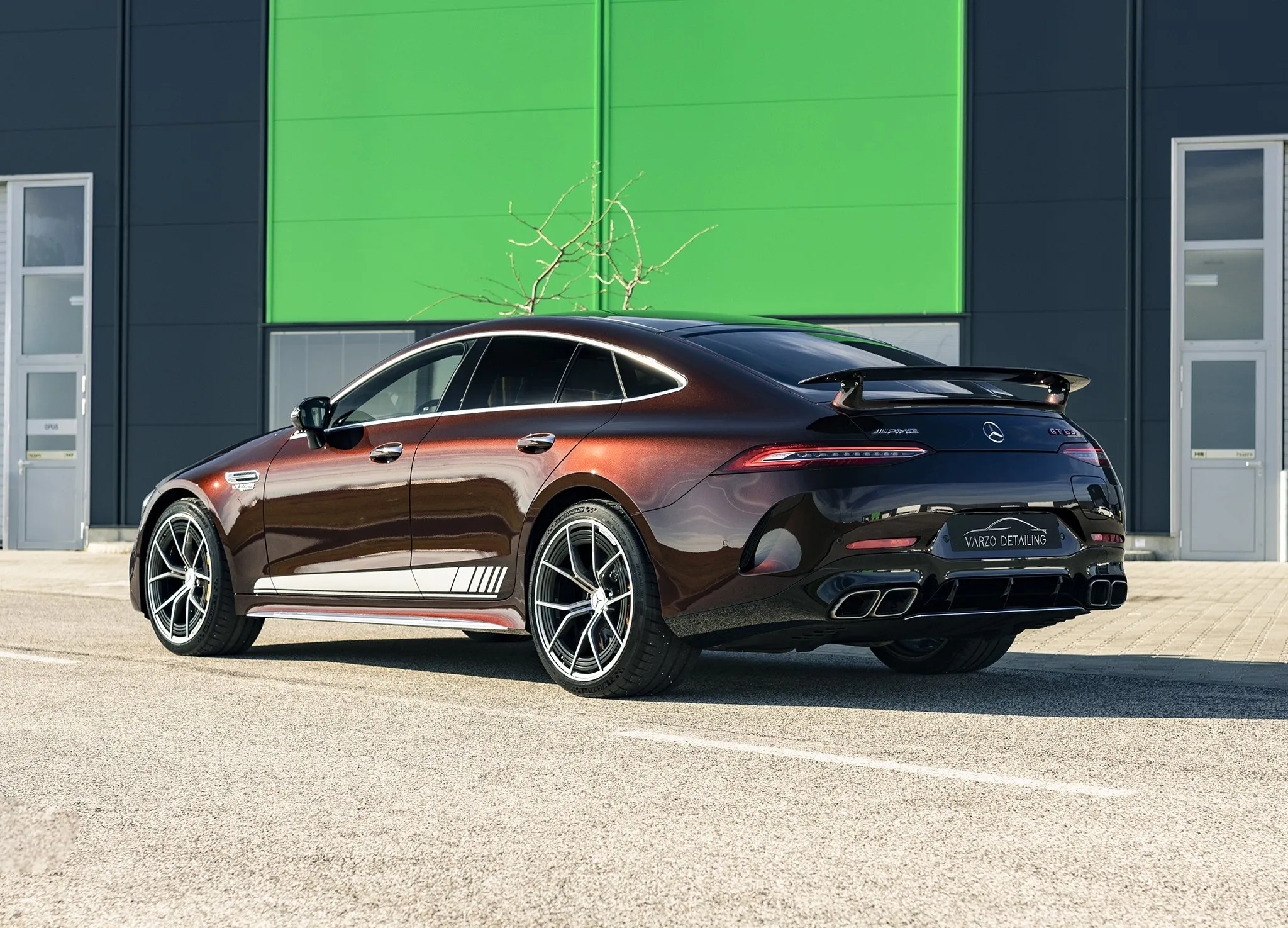 Barna Mercedes-AMG GT négyajtós kupé a műhely előtt