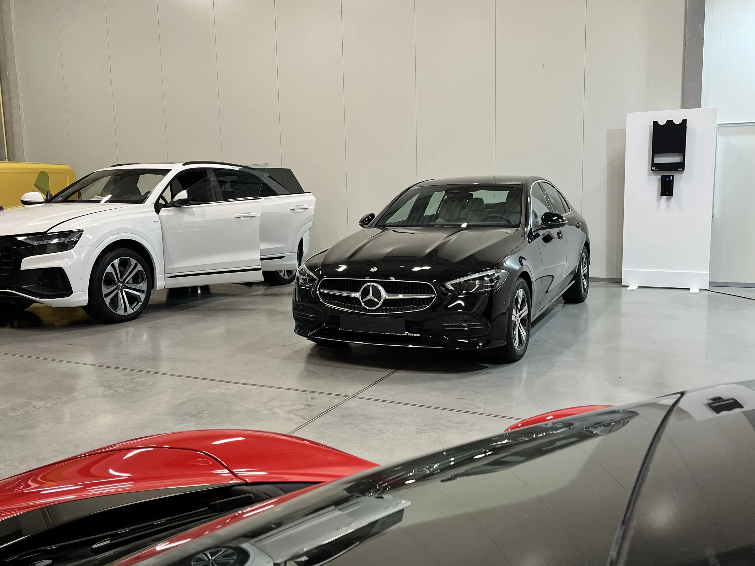 Fekete Mercedes C-osztály és fehér Audi Q8 a Varzo Detailing műhelyében