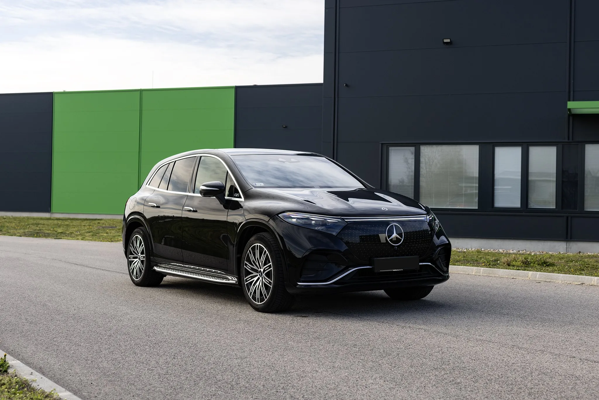 Fekete Mercedes elektromos SUV a műhely előtt